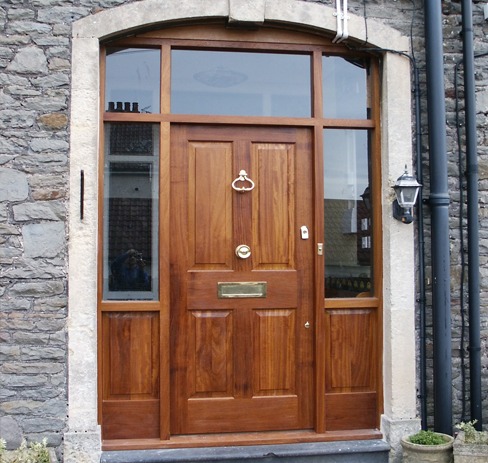 Hardwood panelled front door with glazed side and top lights in a stone house
