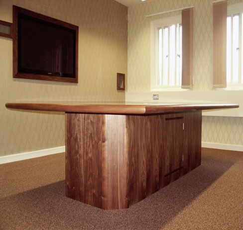Walnut reception counter with a curved top in an office